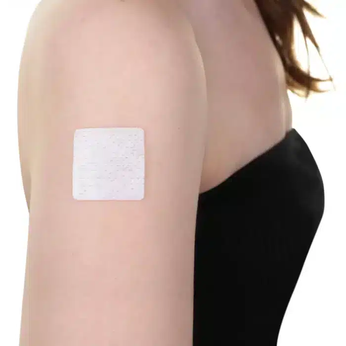 Close-up image of an ACCESS CBD Dermal Patch adhered to a person's arm, showcasing its discreet application.